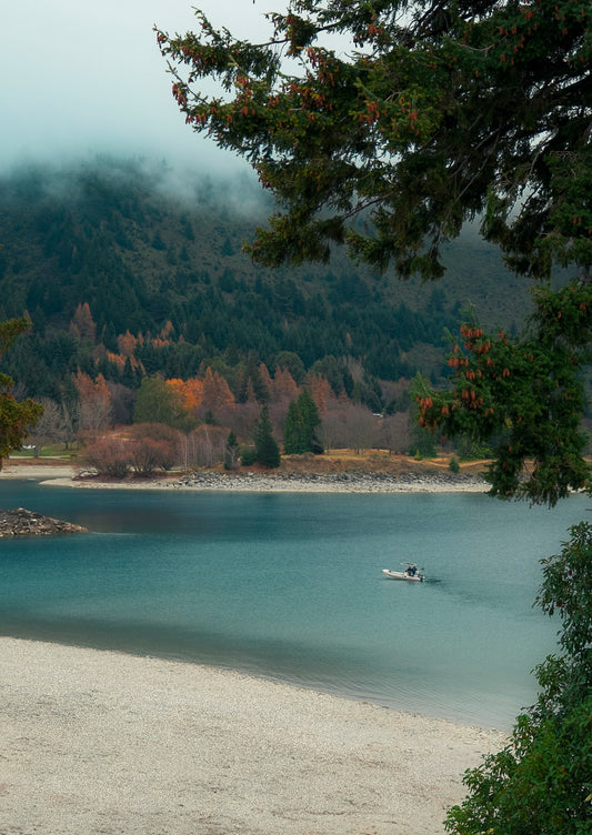 Boat on a lake with trees and mountains in the background